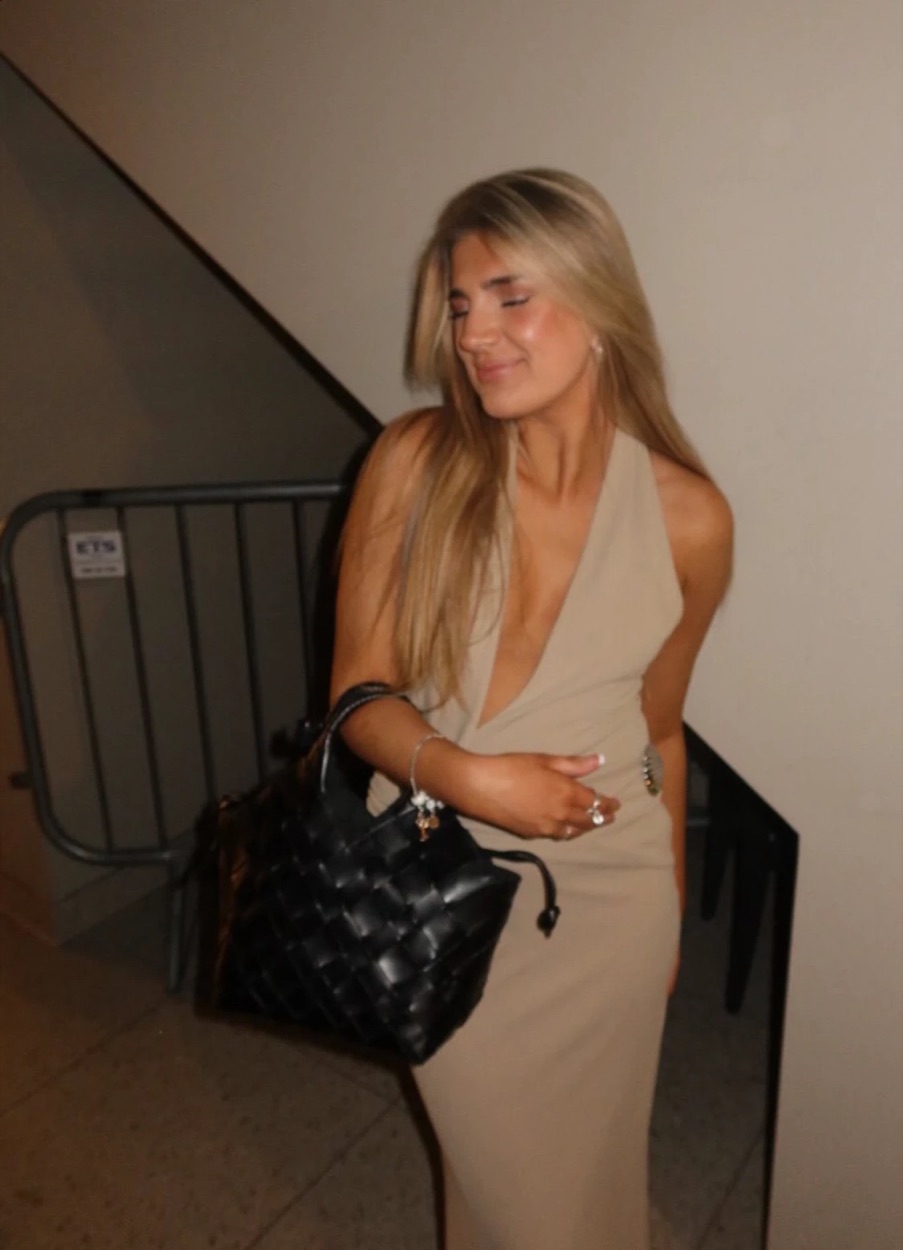 Mariell i beige kjole med svart flettet veske